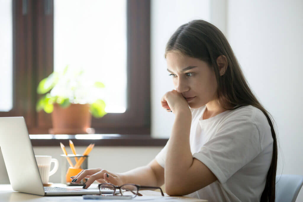 female studying material on laptop