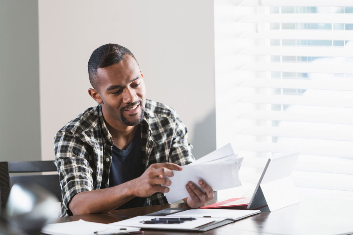 male checking mail at home office desk